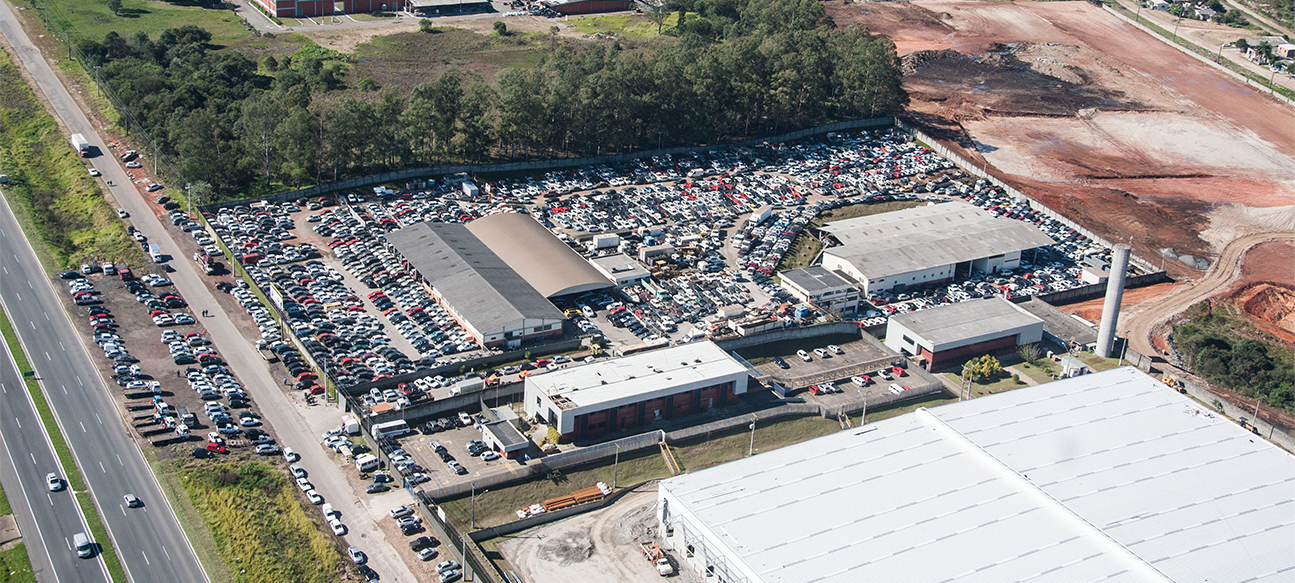 Pátio com diversos veículos organizados para arremate